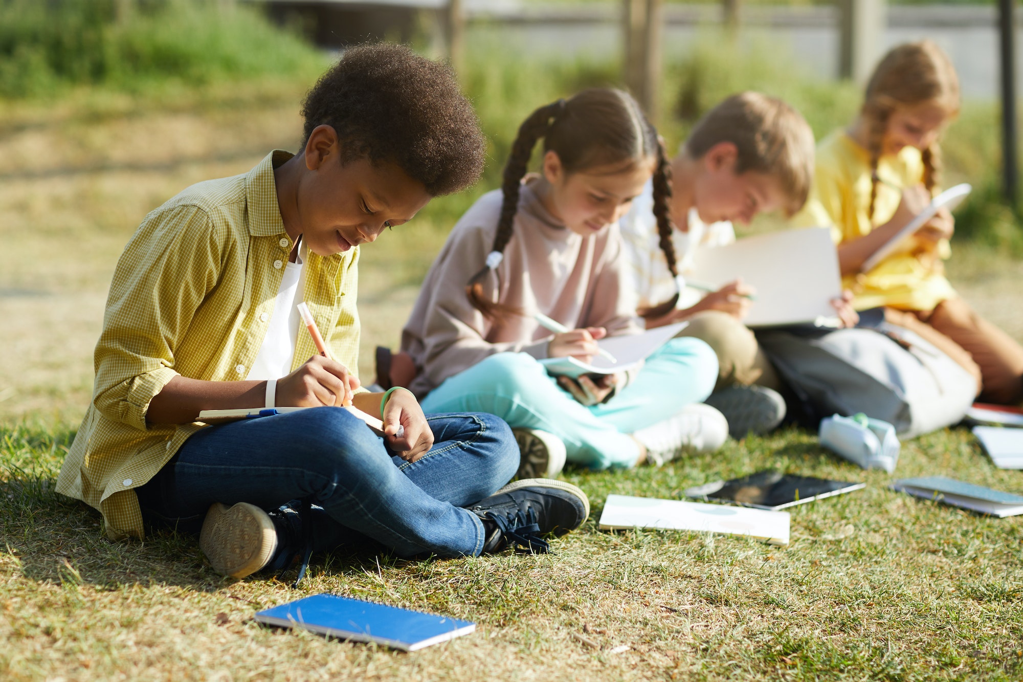 Children Studying on Grass Outdoors